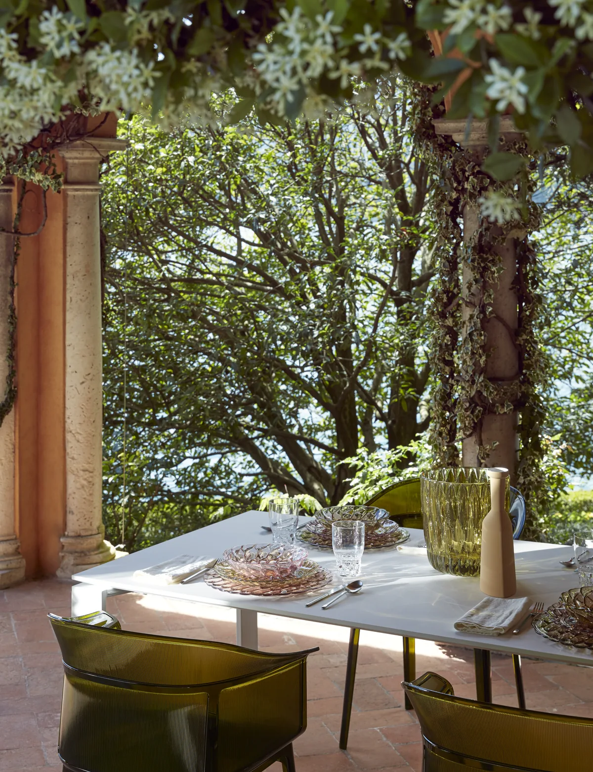 Table dressée sous une pergola avec vue mer — mobilier outdoor Kartell
