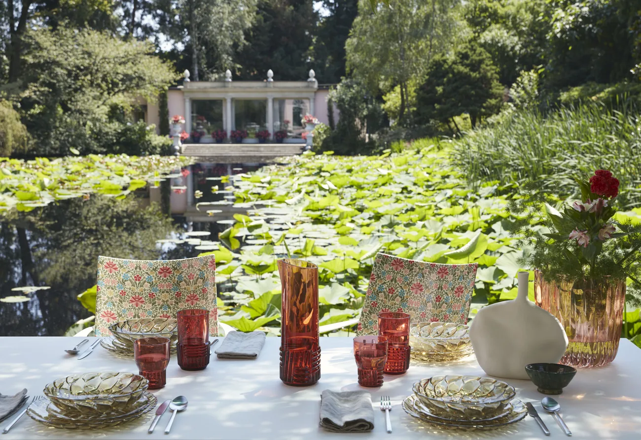 Grande tablée dressée au bord d'un bassin — art de la table Kartell