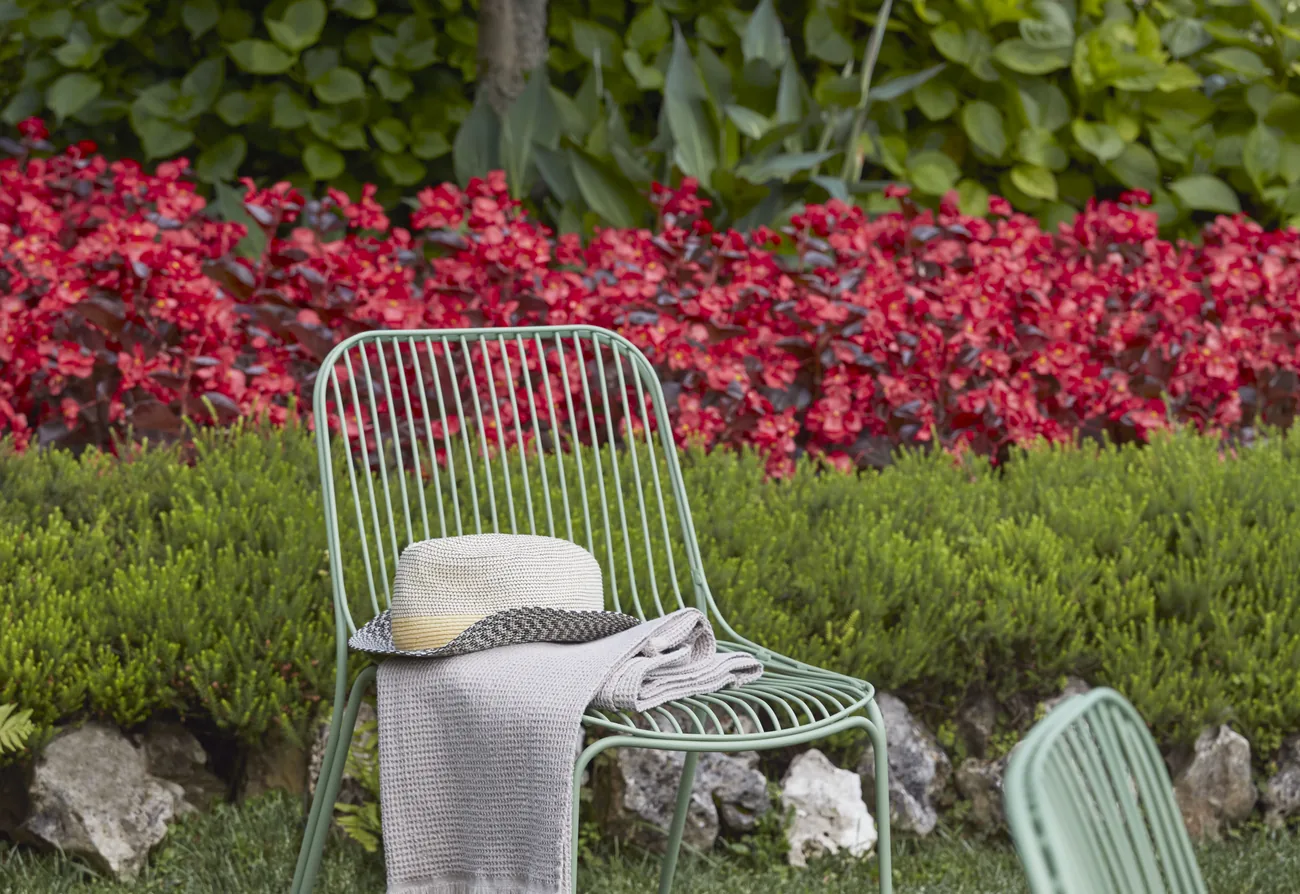 Chaises Kartell sur une pelouse fleurie